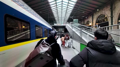 Passengers walking with luggage along a platform next to an Eurostar train at Stock Footage 330858431