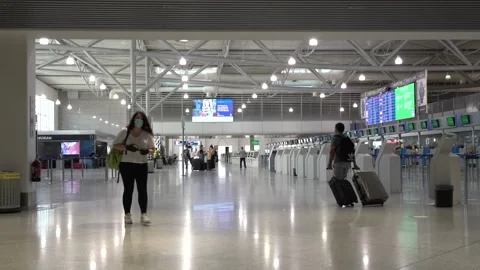 Passengers walking with masks at the empty Athens airport during the pandemi Video stock 142879754