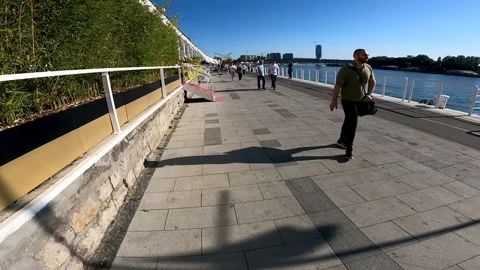 Passengers walking over river Sava promenade in Belgrade, Serbia. Video stock 161056909
