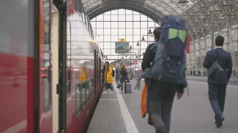 Passengers walking on the platform to catch a train in the railway station Stock Footage 95998072