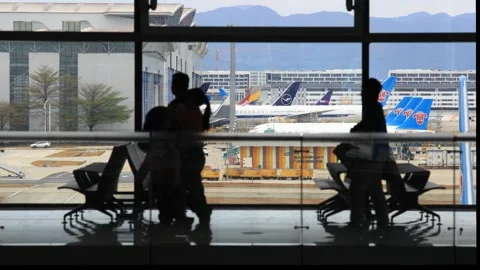 Passengers walking by terminal window, Video stock 304221754