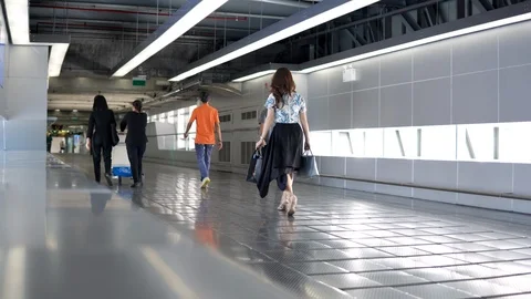 Passengers walking through walkway corridor to airport terminal building Stock-Footage 91100648