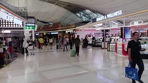 Passengers were walking through the huge duty free area of the airport Stock Footage 289221728