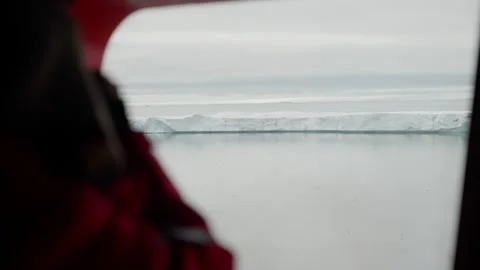 Passengers window view of a solitary tabular iceberg drifting across a calm sea Stock Footage 320687611