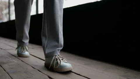 Passerby is strolling alone, closeup view of legs and feet in casual sneakers Video stock 154502326