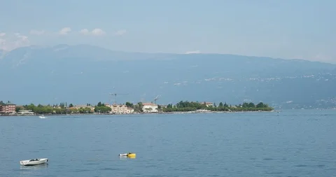 A passing boat in the background of Toscolano-Maderno on Lake Garda Stock Footage