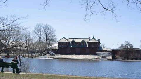 Passing by Charles River in Boston with Two People Sitting on Park Bench Stock Footage 92367436
