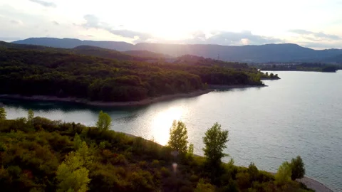 Passing clouds and sunlight over tuscan countryside lake Stock Footage 320848097