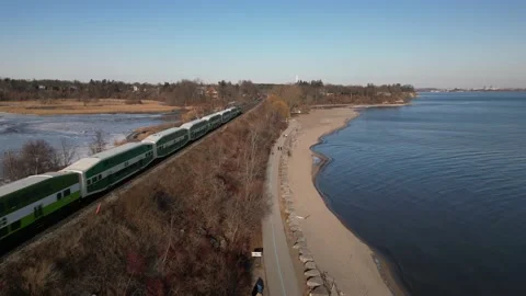 A passing commuter train along Rouge Beach in Scarborogh Ontario Stock Footage 227748851