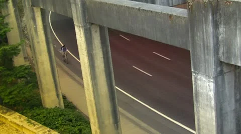 Passing Cyclist And Traffic Through Overpass Support Columns Stock Footage 16291472