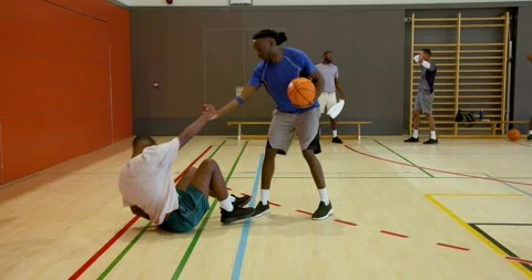 Passing diverse male teammates practicing basketball drills in gym, orange ball Stock Footage 344316291