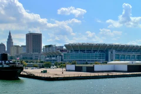 Passing by downtown Cleveland skyline and lakefront stadium Stock Footage