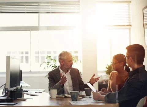 Passing on experience to a new generation. Shot of a group of coworkers in a Stock Photos