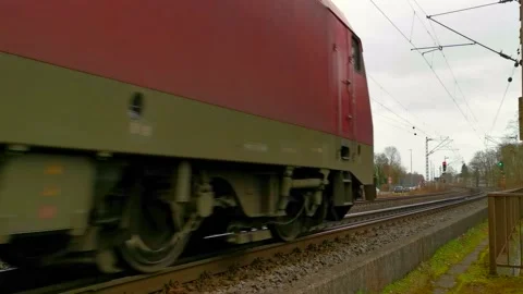 A passing freight train with a red electric locomotive seen from behind Stock Footage 170388498