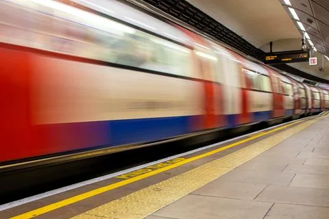 A Passing High Speed Passenger Train Flying Past A Train Station Platform Stock Photos