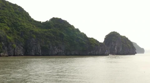 Passing by limestone rocks at sunset, Ha Long Bay, Vietnam. Tracking shot Stock Footage 65476569