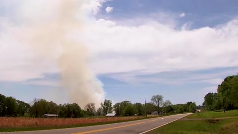 A passing logging semi truck and smoke from a farm land burn Stock Footage 178679857