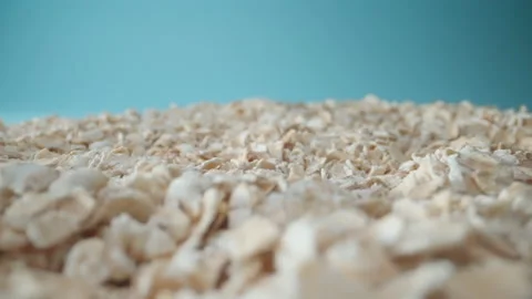 Passing over mountains of oat grains with light blue background Stock Footage 225948069