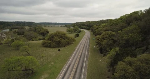 Passing over road tracking cyclist in green landscape drone aerial 4K Stock Footage 111361700