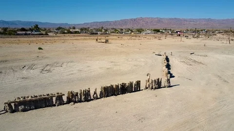 Passing over salt-encrusted pilings on the Shore, heading towards Bombay Beach Stock Footage 113484481