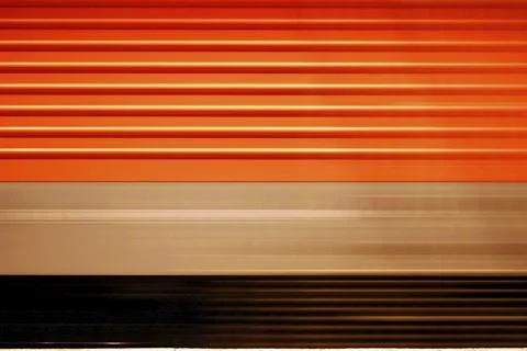 Passing red train with motion blur and a striped pattern Foto stock