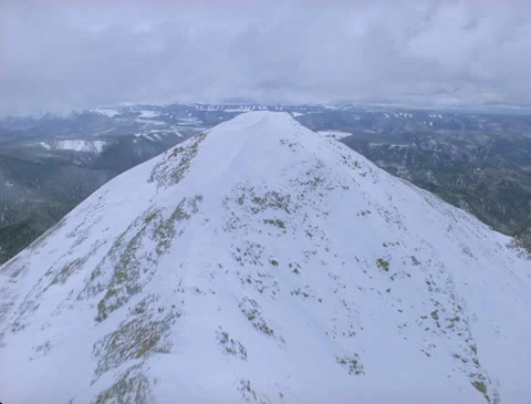 Passing right over snow capped mountain peak 1989 Stock Footage 136071104