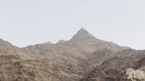 Passing shot of rugged mountain terrain with dirt roads and remote landscape, Vídeo Stock 335289043
