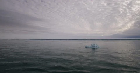 Passing small blue ice berg with glacier in back Stock Footage 61959115