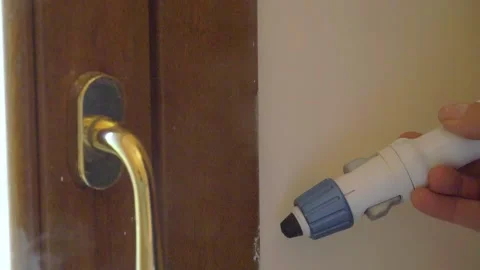 Passing the steam cleaner on the door to remove paint splashes Stock Footage 130698713