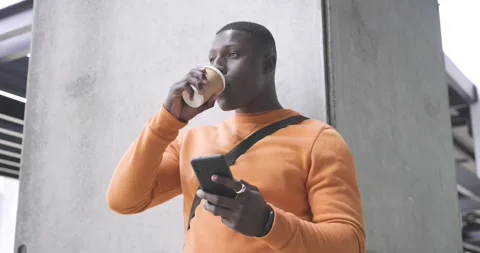 Passing stranger blocking view African American man sipping coffee scrolling Stock Footage 337623966