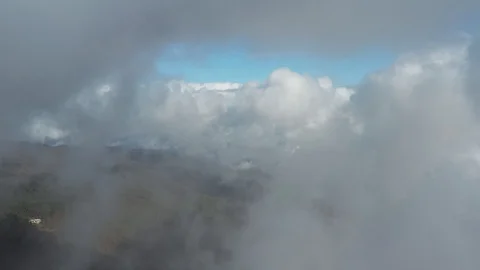 Passing throught fluffy clouds with a view of a autum forest and clear blue s Stock Footage 120747256