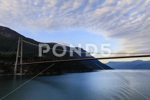 Passing under the huge Hardanger Bridge, sunrise, beautiful dawn clouds, Stock Photos