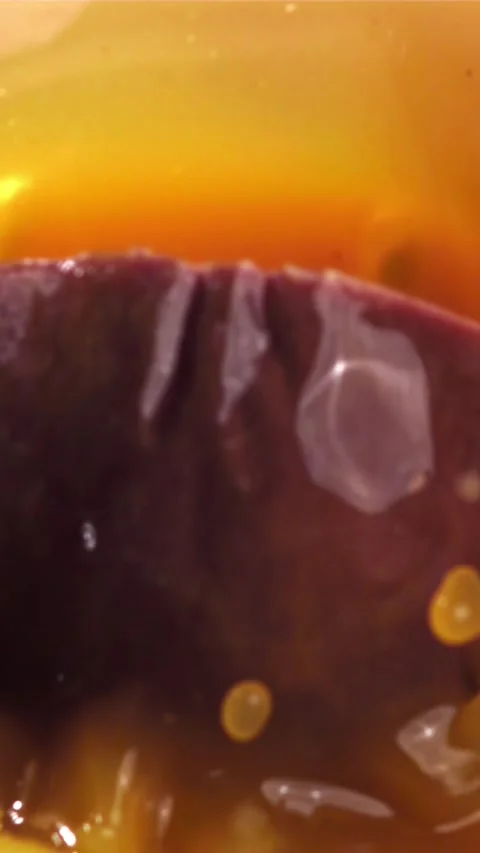 Passion fruit falls into the juice with splashes. Filmed on a high-speed camera Stock Footage 335321844