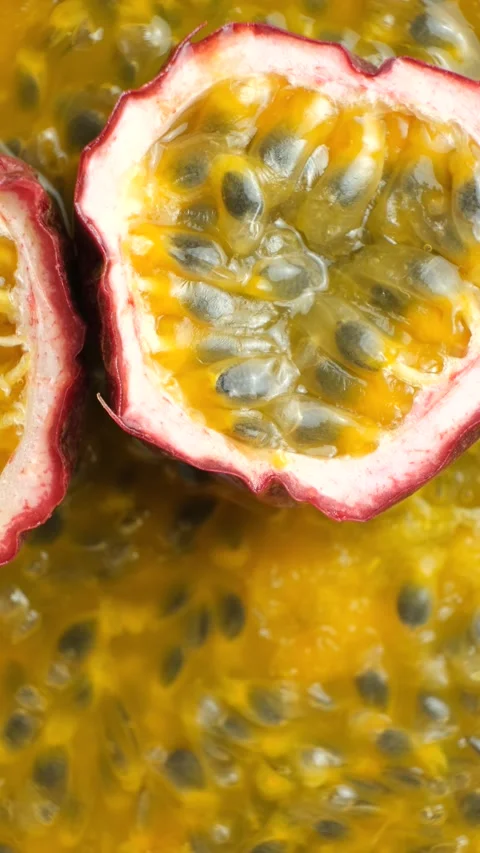 Passion fruit halves rotating slowly over background of juicy pulp, copy space f Stock Footage 344955534