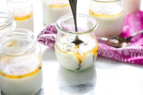 Passion fruit panna cotta on tiny glasses and pink napkin Stock Photos