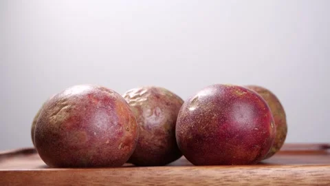 Passion Fruit rotate in slow motion on a wooden table Stock Footage 142774752