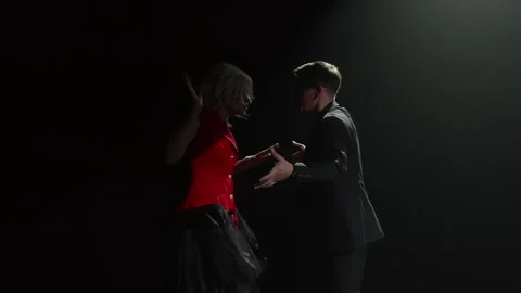 Passionate dancers performing tango on stage with dramatic lighting Stock Footage 304947056