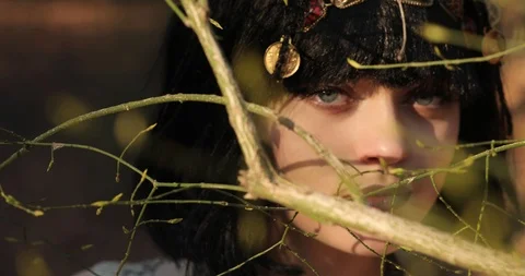 Passionate look between the branches of the trees. green eyes. Cleopatra's eyes. Vídeo Stock 126634460