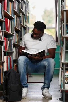Passionate reader, student, african studying textbook in university library Stock Photos