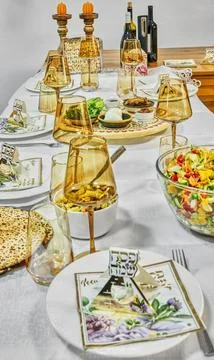Passover seder table setting with glassware, matzah, symbolic food, and han.. Stock Photos