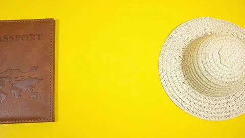 Passport and straw hat moving on a yellow background Video stock 287702398