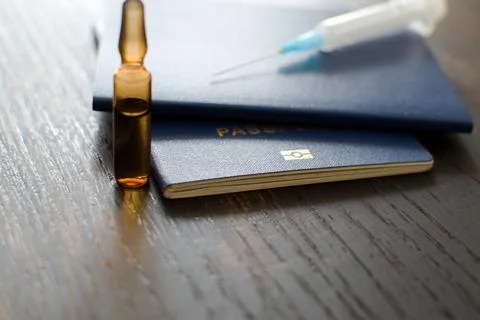 Passport chip on blurred background of table with ampoule and syringe Stock Photos