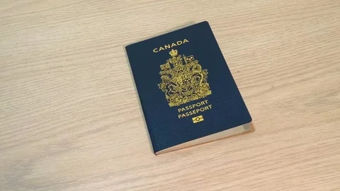 Passport falling onto a light wooden table, travel document dropping for 動画素材 318311017