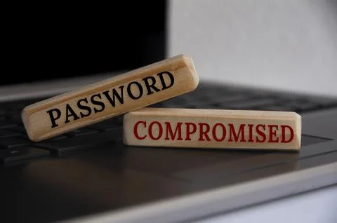 Password compromised text on wooden blocks on top of a laptop. Stock Photos