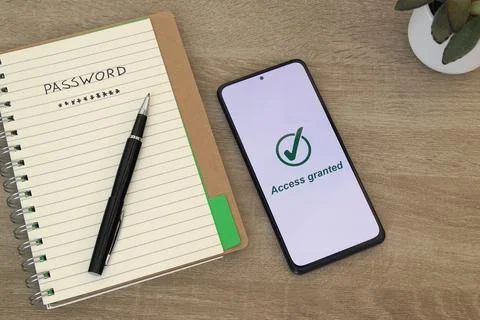 Password Notebook and Smartphone Displaying Access Granted Stock Photos