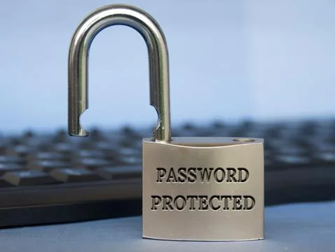 Password protected text engraved on padlock with blurred keyboard background Stock Photos