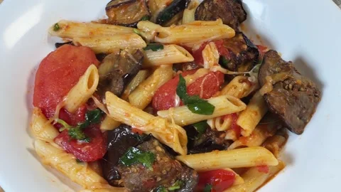 Pasta with baked eggplants, tomatoes, fresh basil and grated cheese Stock Footage 345669504