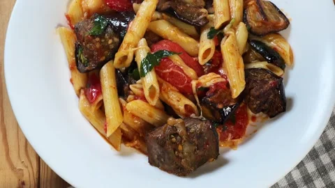 Pasta with baked eggplants, tomatoes, fresh basil and grated cheese Stock Footage 345669594