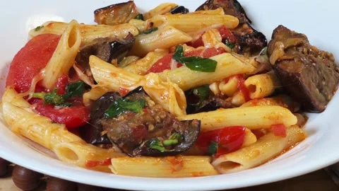 Pasta with baked eggplants, tomatoes, fresh basil and grated cheese Stock Footage 345669718
