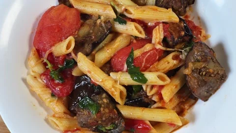 Pasta with baked eggplants, tomatoes, fresh basil and grated cheese Stock Footage 345669736
